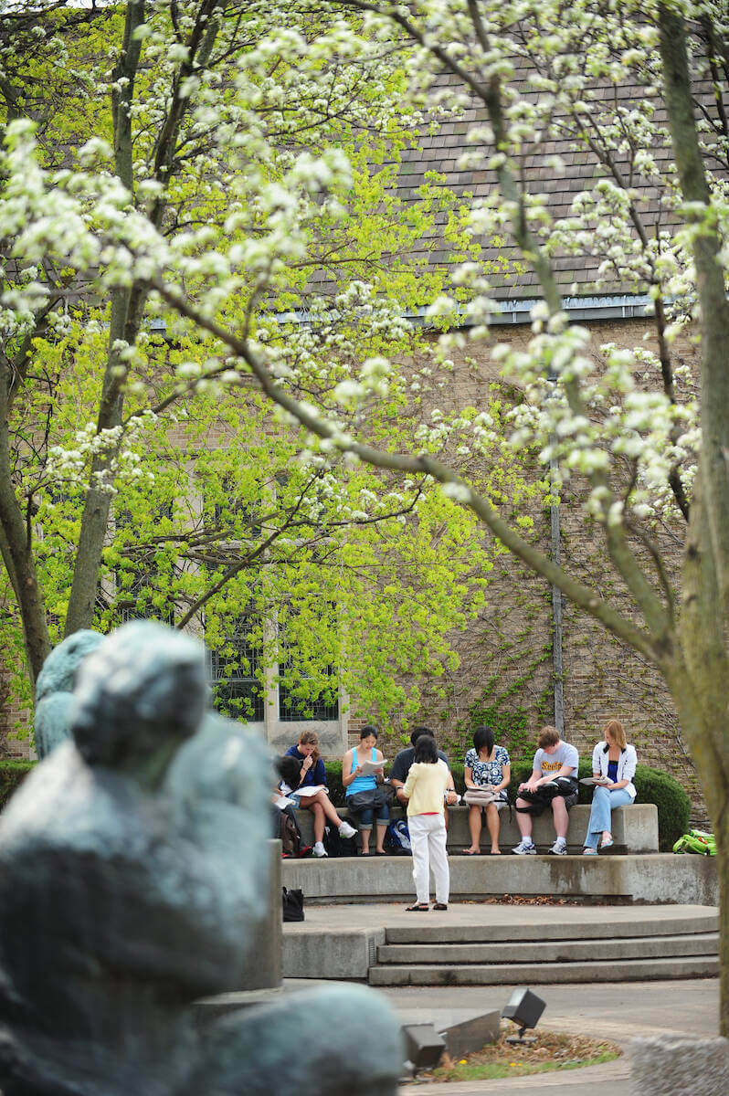Students taking notes during a class outside O'Shaugnessy Hall